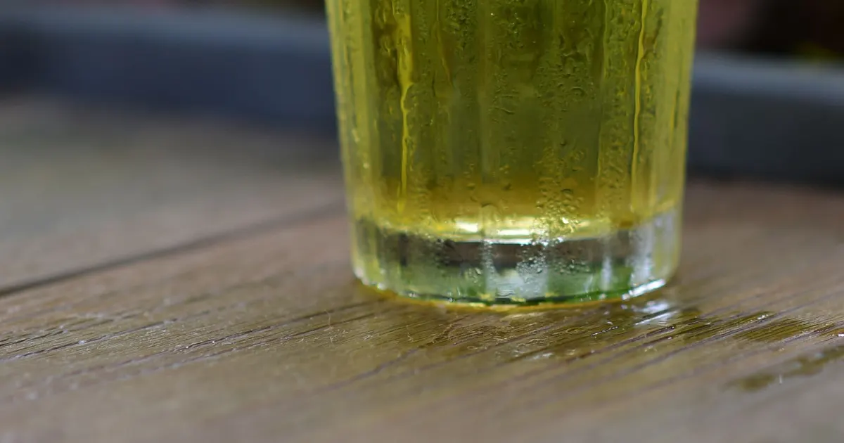 A tall glass of chilled green tea with condensation on the outside, the kind of drink made from green tea for RTD beverages