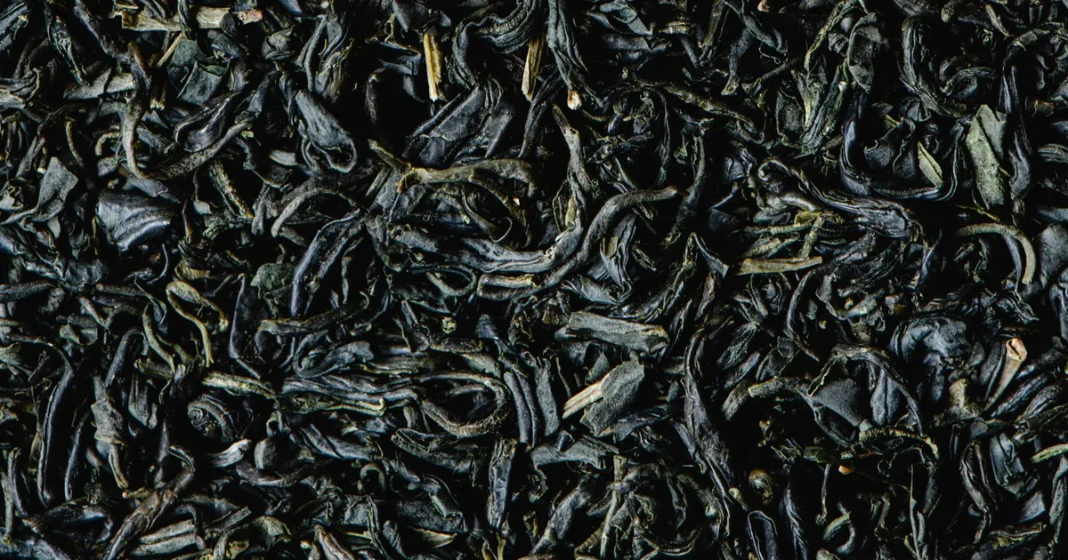 Close-up of dark dried green tea leaf, the product whose green tea moisture content is measured and specified